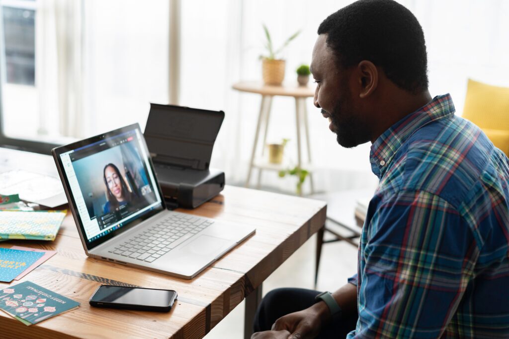 A man sitting at his desk looking at a laptop